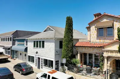 a group of buildings with cars parked in a parking lot at Luxe Balboa House 5 Bedroom 5 Ensuite Bath Peninsula Ferry Close in Newport Beach