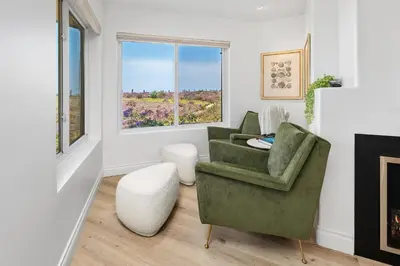 a living room with a green chair and a window at Surf Song Symphony - SONG55 in Solana Beach