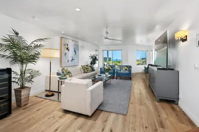 a living room with a couch and a tv at Surf Song Symphony - SONG55 in Solana Beach