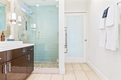a bathroom with a shower and a glass door at Coastal Escape Ping Pong Bikes and Steps to Sand in San Diego