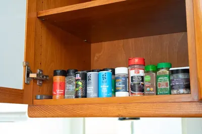 a wooden cabinet with a row of different colored liquids at Coastal Escape Ping Pong Bikes and Steps to Sand in San Diego