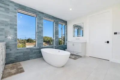 a large bathroom with a tub and windows at Luxury Pool Haven Scenic Views and Summer Fireworks in San Diego