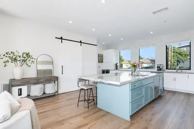 a kitchen with white walls and a blue island at Luxury Pool Haven Scenic Views and Summer Fireworks in San Diego