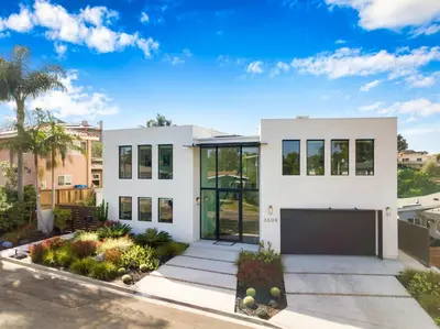a white house with a lot of windows at Luxury Pool Haven Scenic Views and Summer Fireworks in San Diego