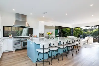 a kitchen with a blue island with bar stools at Luxury Pool Haven Scenic Views and Summer Fireworks in San Diego