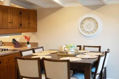 a dining room table with chairs and a clock on the wall at Chic Retreat Ping Pong, Bonfires and Patio Leisure in San Diego
