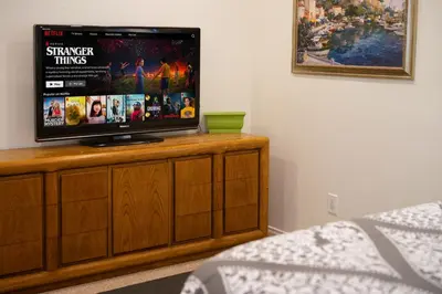 a flat screen tv sitting on top of a wooden entertainment center at Chic Retreat Ping Pong, Bonfires and Patio Leisure in San Diego