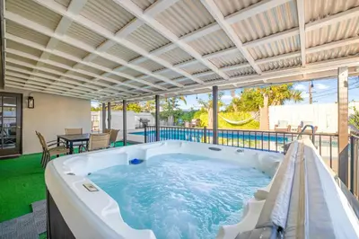 a hot tub in the middle of a patio with a table at Serene Sanctuary Pool, Hot Tub and Game Room in San Diego