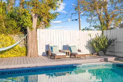 two chairs and a hammock next to a swimming pool at Serene Sanctuary Pool, Hot Tub and Game Room in San Diego