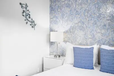 a bedroom with a bed with blue wallpaper at Serene Sanctuary Pool, Hot Tub and Game Room in San Diego