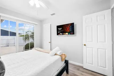 a white bedroom with a bed and a window at Serene Sanctuary Pool, Hot Tub and Game Room in San Diego