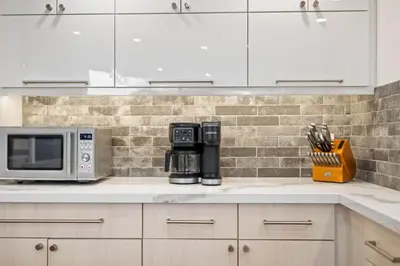 a kitchen with white cabinets and a microwave at Clairemont Mesa Chic 4BR with Patio and Hot Tub in San Diego