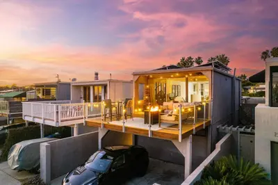a house with a wrap around deck with a sunset at Modern Pacific Beach Retreat with Hot Tub and Views in San Diego