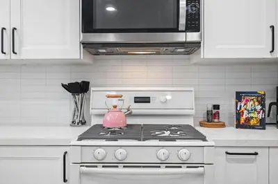 a kitchen with a stove with a pink pot on it at Modern Pacific Beach Retreat with Hot Tub and Views in San Diego