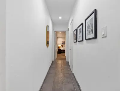 a hallway with white walls and pictures on the walls at Modern Pacific Beach Retreat with Hot Tub and Views in San Diego