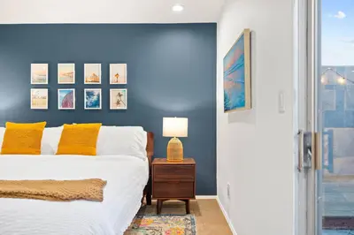 a bedroom with a bed and a blue wall at Modern Pacific Beach Retreat with Hot Tub and Views in San Diego
