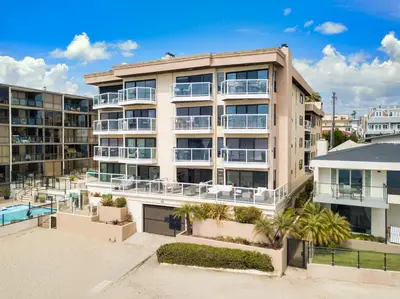 an apartment building with a pool in front of it at Crown Point 3BR Bay and Beach View Parking W D in San Diego