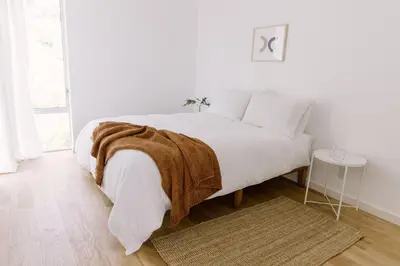 a white bedroom with a bed with a blanket on it at Glass Home with Views, Hot Tub, FREE EV Charging! in Bonita
