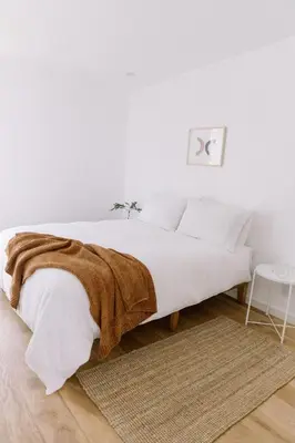 a white bedroom with a bed with a blanket on it at Glass Home with Views, Hot Tub, FREE EV Charging! in Bonita