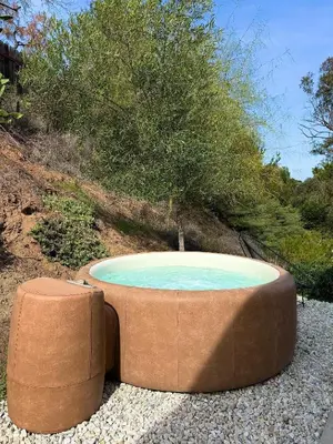 a large circular pool with two ottomans at Glass Home with Views, Hot Tub, FREE EV Charging! in Bonita
