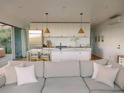 a living room with a couch and a kitchen at Glass Home with Views, Hot Tub, FREE EV Charging! in Bonita