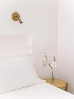 a white bed with a vase of flowers on a table at Glass Home with Views, Hot Tub, FREE EV Charging! in Bonita