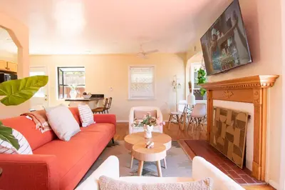 a living room with a red couch and a fireplace at Walk to Beach • La Jolla Home + Free Parking in San Diego