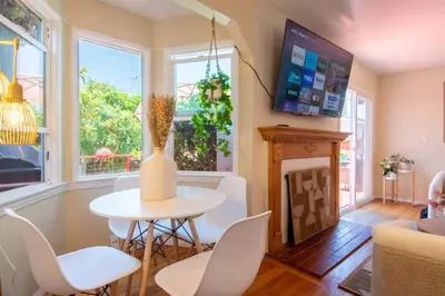 a living room with a table and chairs and a fireplace at Walk to Beach • La Jolla Home + Free Parking in San Diego