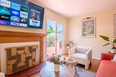 a living room with a fireplace and a flat screen tv at Walk to Beach • La Jolla Home + Free Parking in San Diego