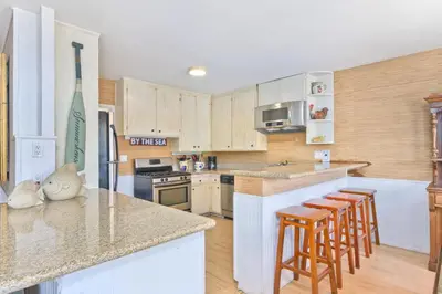 a kitchen with wooden cabinets and a counter with bar stools at Costa del Sol in Newport Beach
