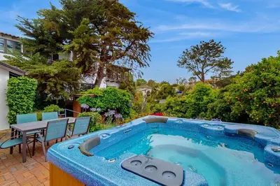 a swimming pool in a yard with a table and chairs at La Jolla Historic Gem, Hot Tub, Game Room, Garden Oasis with Firepit & Courtyard Dining in San Diego