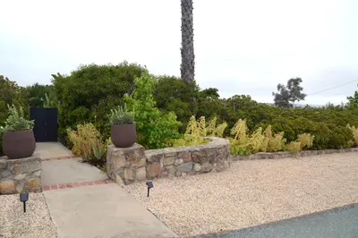 a garden with potted plants and a stone wall at Casa Grotto in San Marcos