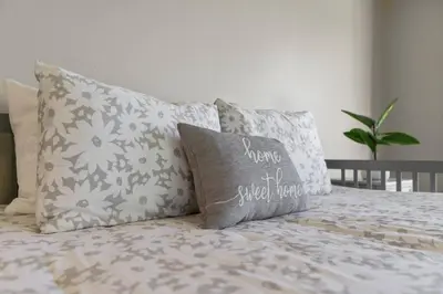 a bed with pillows and a pillow that says youre sweet home at Sunset Crest - Home with stunning views, Pool, BBQ in Fallbrook