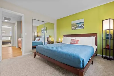 a bedroom with a king sized bed and a mirror at Sunset Crest - Home with stunning views, Pool, BBQ in Fallbrook