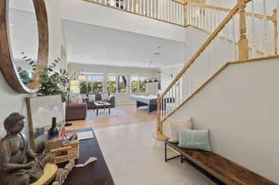 a living room with a staircase with a statue on a table at Sunset Crest - Home with stunning views, Pool, BBQ in Fallbrook