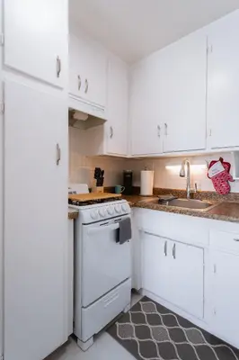 a white kitchen with a stove and a sink at King Suite - 2min Walk to Beach Close to Downtown! in Oceanside