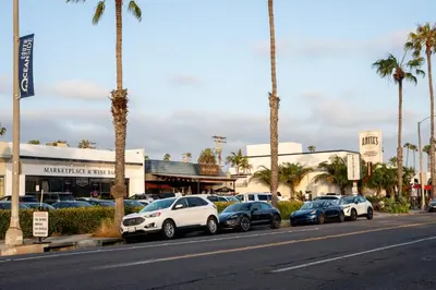 a row of cars parked in a parking lot with palm trees at King Suite - 2min Walk to Beach Close to Downtown! in Oceanside