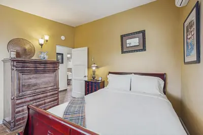 a bedroom with a bed with a wooden headboard at Seabreeze Bungalow in Oceanside