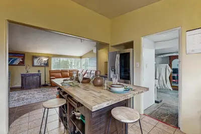 a kitchen with a large island with two stools at Seabreeze Bungalow in Oceanside