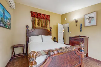 a bedroom with a large bed with a wooden headboard at Seabreeze Bungalow in Oceanside