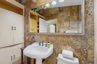 a bathroom with a sink and a toilet and a mirror at Seabreeze Bungalow in Oceanside
