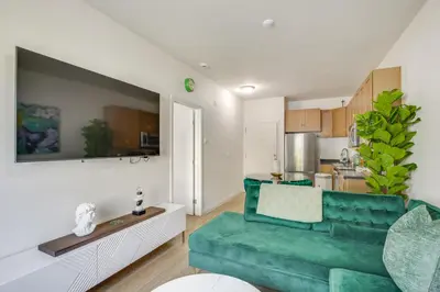 a living room with a green couch and a kitchen at Golden Hill Gem 2 Mi to Gaslamp Quarter - Dogs OK! in San Diego