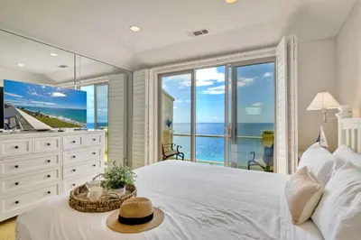 a bedroom with a white bed with a view of the ocean at Beachfront Sunset in Encinitas