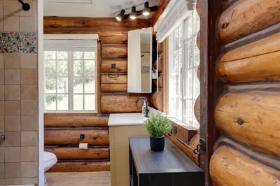 a bathroom in a log cabin with a sink and a mirror at Hike, Bike and Explore Woodsy Retreat in Mt Laguna! in Mount Laguna