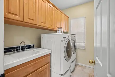 a kitchen with a washing machine and a sink at Explore Ramonas Vineyards Tranquil Home with Yard in Ramona
