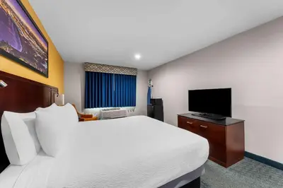 a hotel room with a large bed and a flat screen tv at Quality Inn San Diego South - Chula Vista in Chula Vista