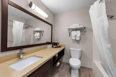 a bathroom with a sink and a mirror and a toilet at Quality Inn San Diego South - Chula Vista in Chula Vista