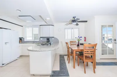 a kitchen and dining room with a table and chairs at Pet-Friendly 4Br Oceanview Getaway Steps From 35Th St Beach By Beachview Rentals in Newport Beach