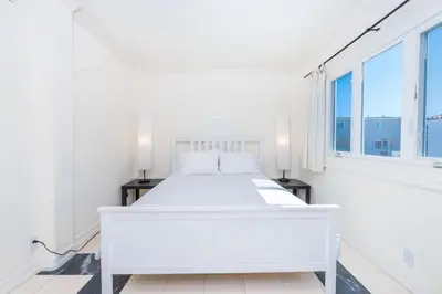 a white bed in a white room with windows at Pet-Friendly 4Br Oceanview Getaway Steps From 35Th St Beach By Beachview Rentals in Newport Beach