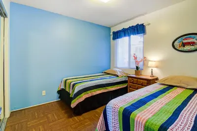 two beds in a room with blue walls at Retro 3Br With Oceanview Patio In A Very Walkable Location By Beachview Rentals in Newport Beach